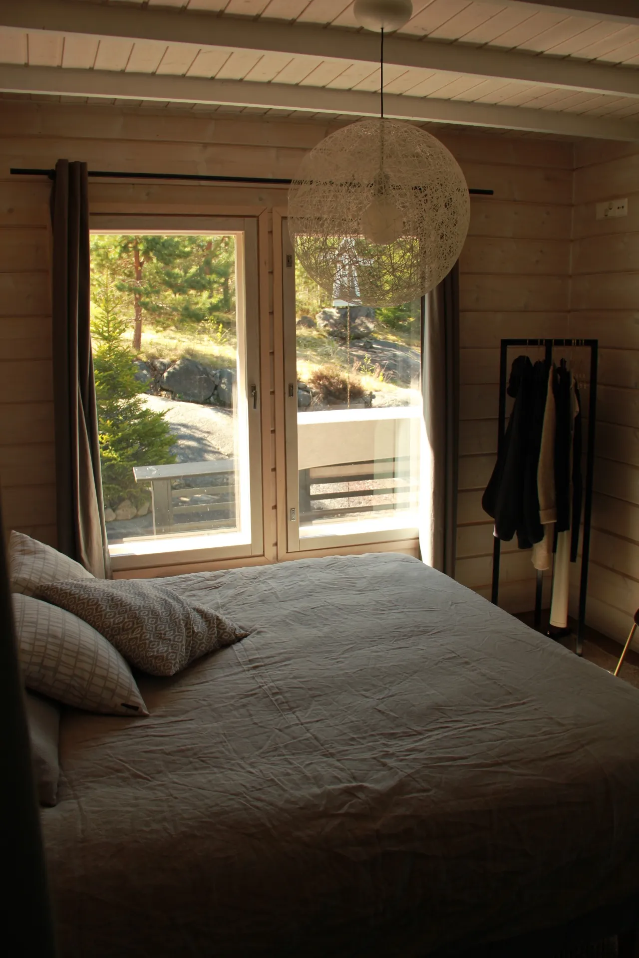 Bedroom with forest view through balcony doors