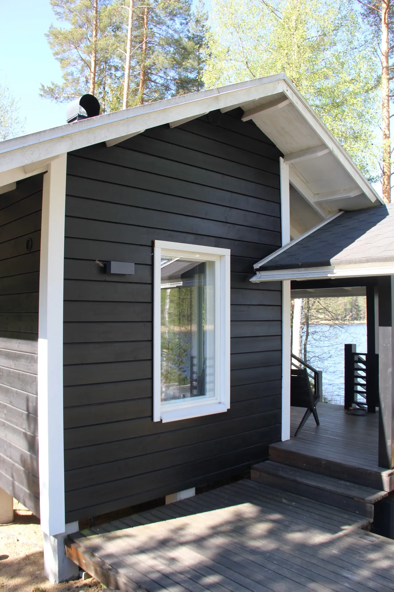 Black-stained cottage facade with covered porch