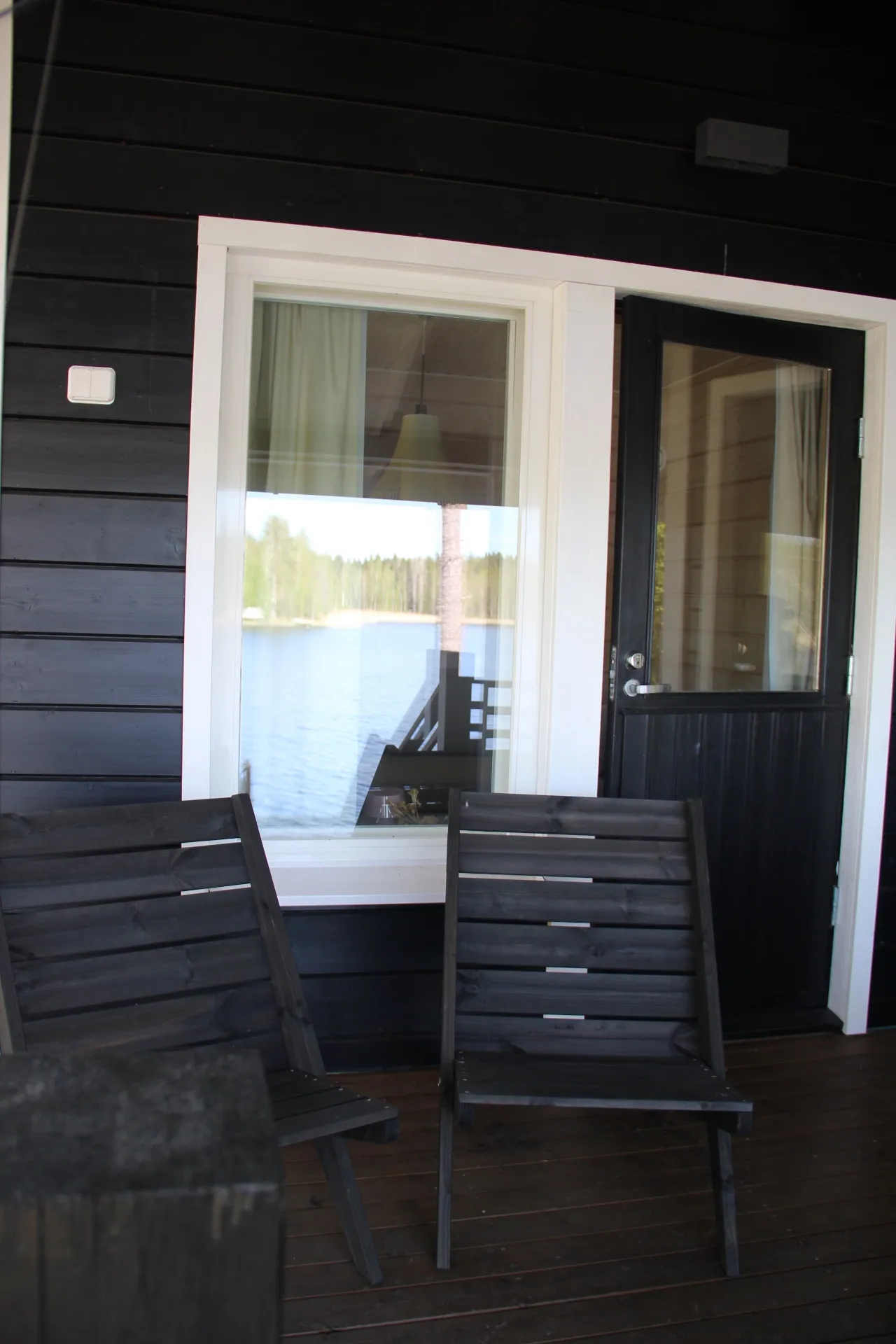 Covered porch with chairs and lake view through the window
