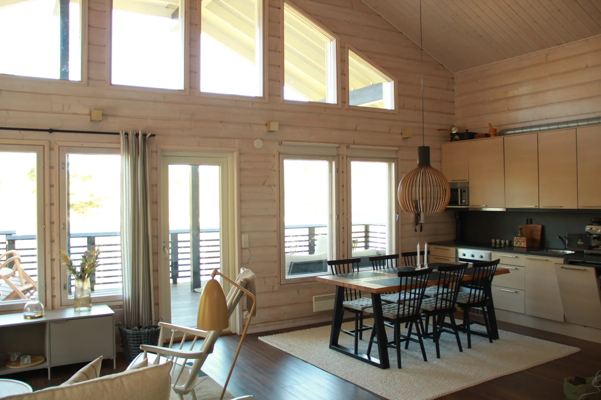 Dining table, kitchen and tall windows in afternoon light