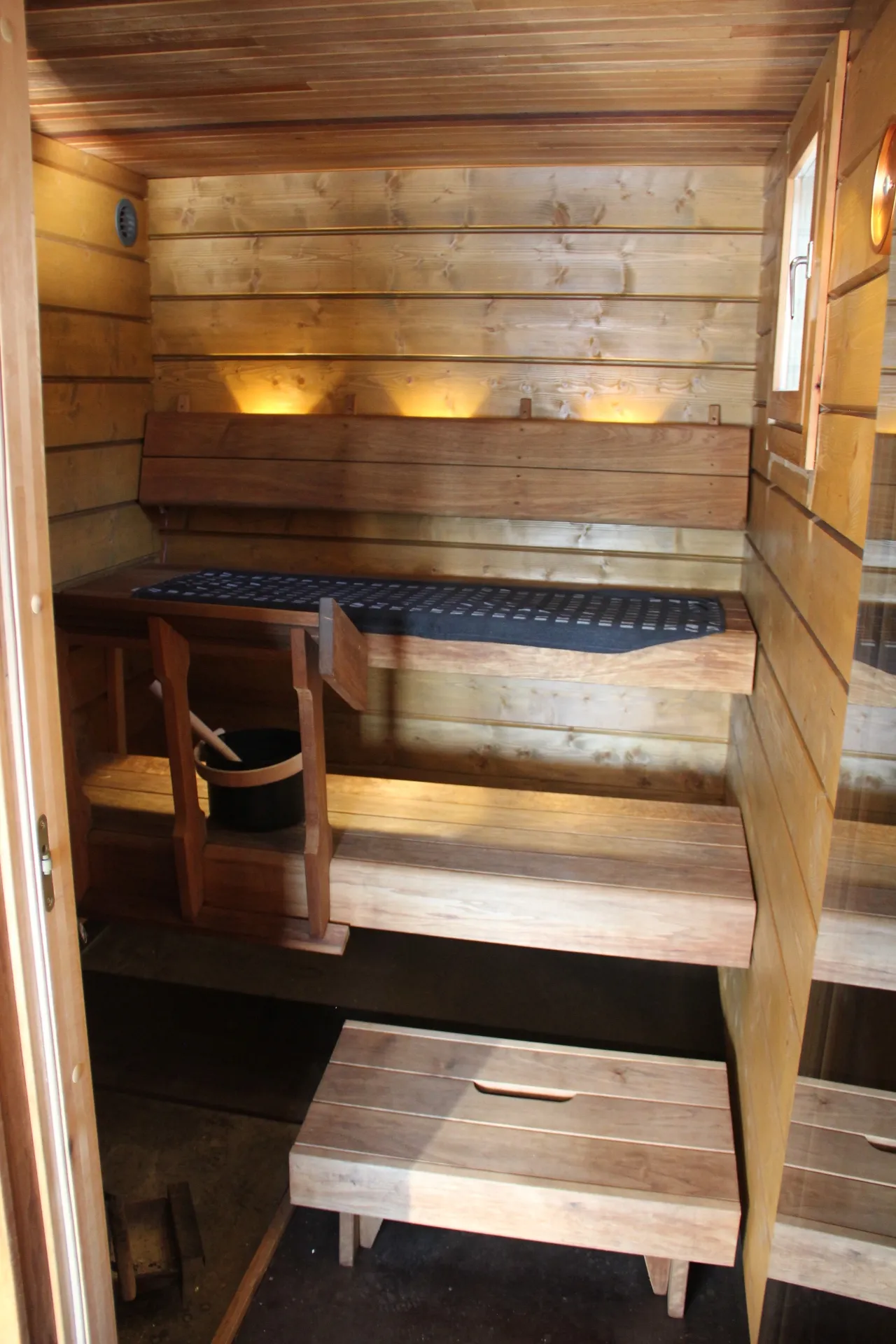 Warm-wood sauna benches with backrest lighting