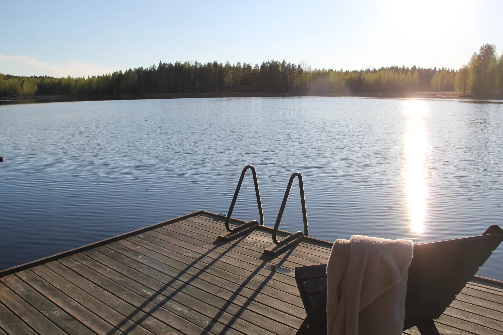 Pier and swim ladder with sunlight glinting on the lake