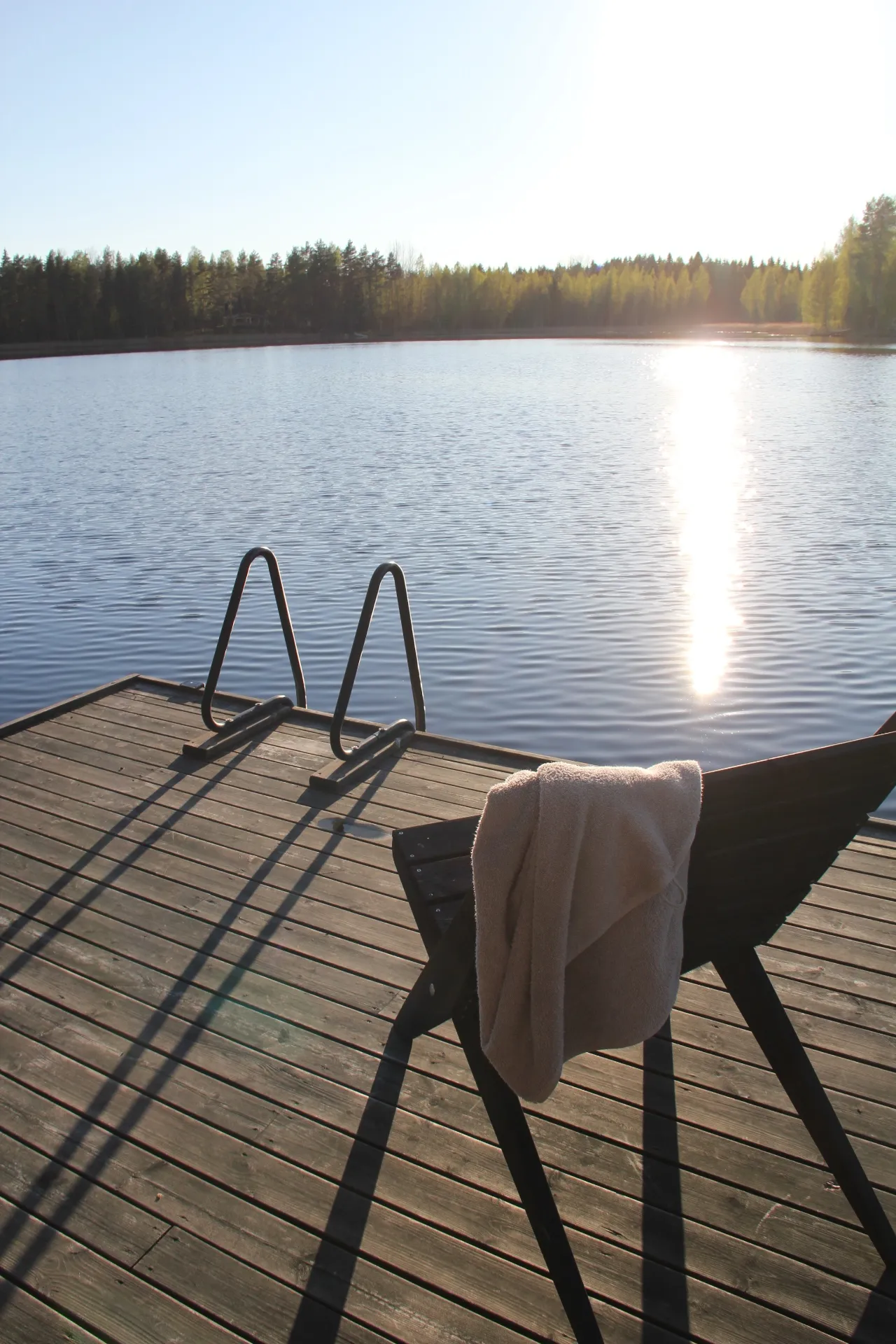 Lounge chair and swim ladder facing the evening sun