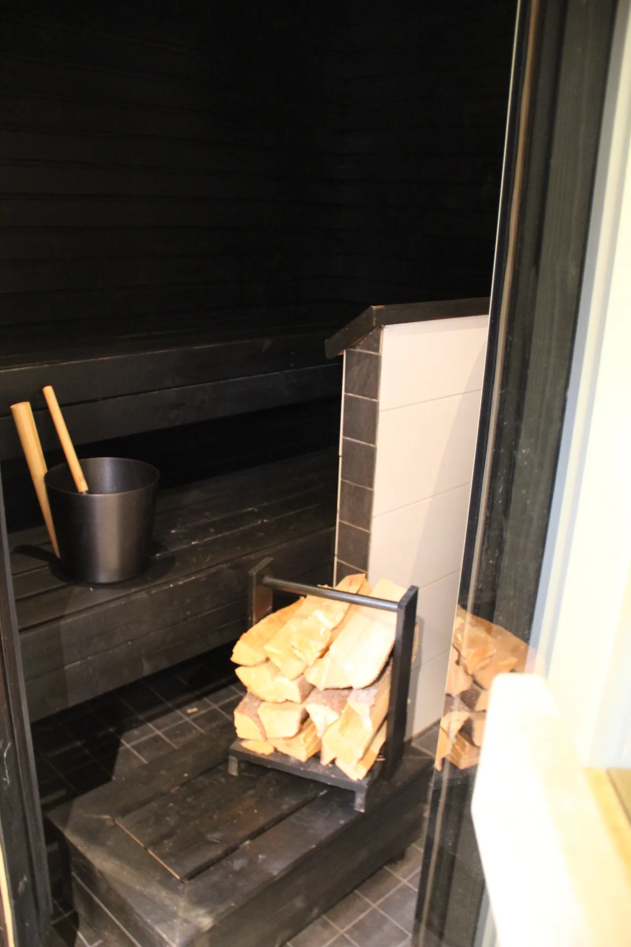 Sauna benches with firewood stacked beside the stove