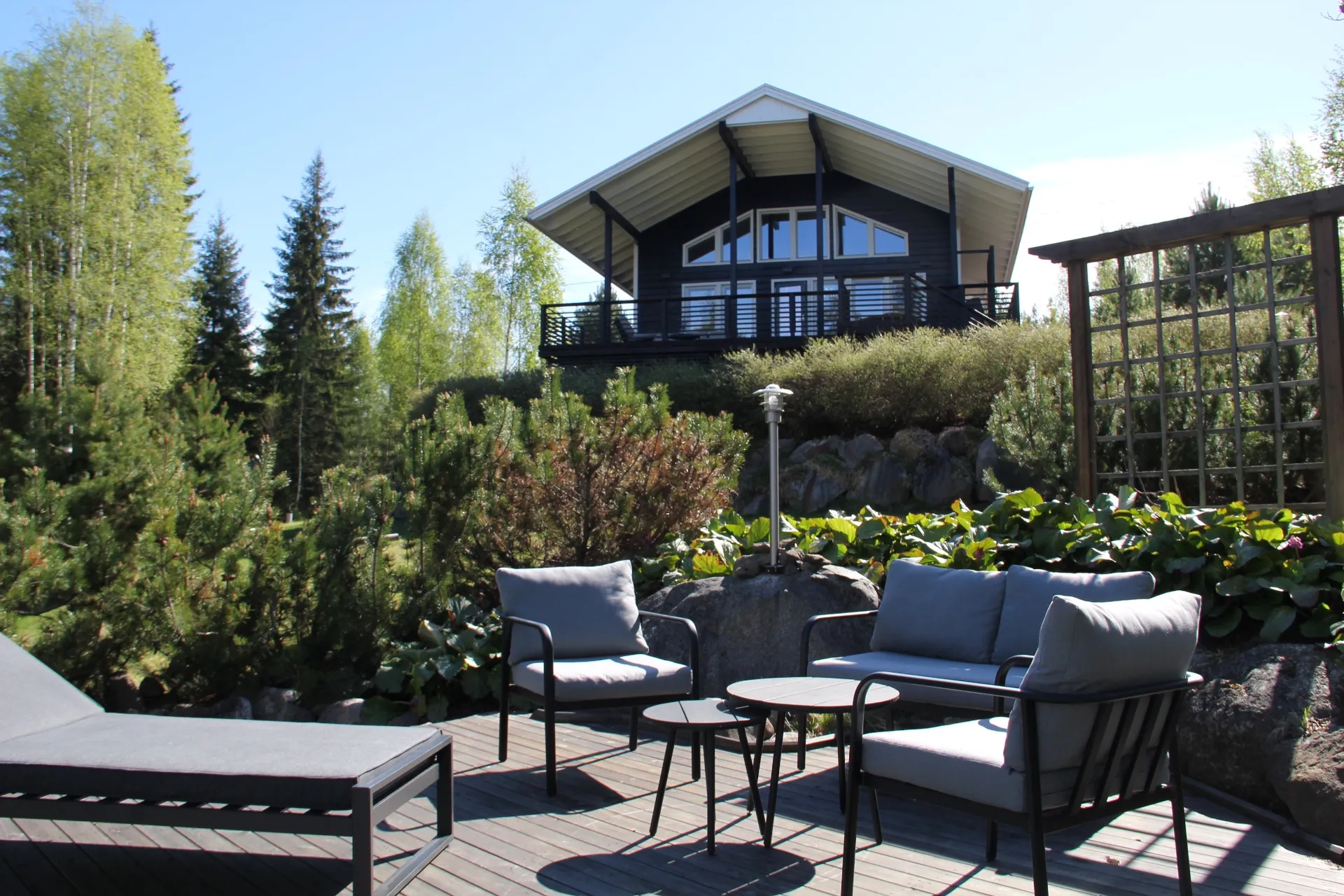 Garden terrace with sofa, armchairs and trellis